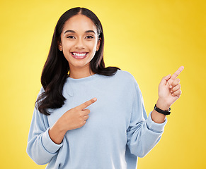 Image showing Yellow background, point and portrait of woman with smile for advertising, promotion and announcement. Mockup space, studio and isolated happy girl with hand gesture for information, discount or news