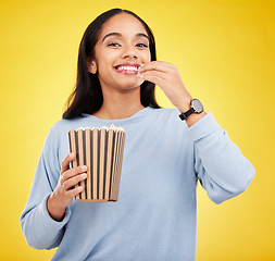 Image showing Woman is eating popcorn, happiness and portrait with snack for watching tv or movie on yellow studio background. Streaming service, film and food with corn treat, young female with smile and cinema