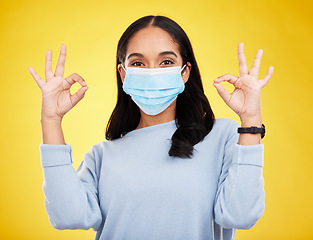 Image showing Covid, okay sign and portrait of woman in studio for positive, illness and approval. Protection, prevention and disease with female isolated on yellow background for medical, healthcare and pandemic