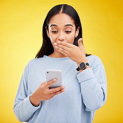 Image showing Shock, surprise and woman in studio with phone and hand on mouth isolated on yellow background. Social media, fake news or exciting online promotion, hispanic girl reading notification on smartphone.