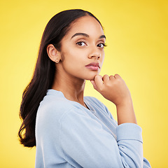 Image showing Portrait, thinking and a woman on a yellow background in studio feeling thoughtful or contemplative. Face, idea and an attractive young female standing hand on chin while contemplating a thought