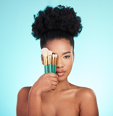 Image showing Portrait, brushes and black woman with skincare, cosmetics and treatment against blue studio background. Face, African American female and lady with cosmetic tools, grooming and confidence with glow