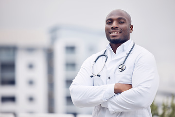 Image showing African, man and doctor in city for portrait, arms crossed and smile for wellness, healthcare and mockup. Young black medic, confidence and happy in metro with blurred background for mock up space