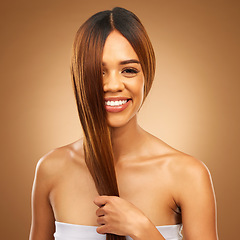 Image showing Haircare, smile and portrait of woman in studio holding strong hair in hand with texture and shine. Happy model, mockup and beauty, healthy straight hairstyle with keratin product on brown background