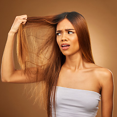 Image showing Hair, problem and woman in studio frustrated with hair loss, split ends or damage against a brown background. Haircare, crisis and girl model with knot, messy and annoyed with salon results isolated