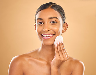 Image showing Skincare, happy and portrait of woman with cotton for facial cleansing isolated on a background. Smile, beauty and an Indian model cleaning her face with a pad for gentle treatment and makeup removal