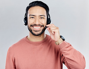 Image showing Asian man, portrait smile and headphones with mic for call center or online customer service against a white studio background. Happy male consultant with headset smiling for wireless communication