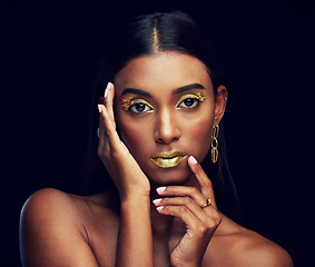 Image showing Gold makeup, serious and portrait of a woman isolated on a black background in a studio. Beauty, young and glamorous Indian model posing with creative cosmetics, jewelry and stylish on a backdrop