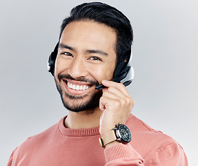 Image showing Asian man, portrait smile and headphones with mic for call center or online customer service against a white studio background. Happy male consultant with headset smiling for wireless communication