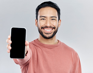 Image showing Asian man, portrait smile and phone mockup for advertising or marketing against a white studio background. Happy male smiling with smartphone screen or display for mobile app advertisement or brand