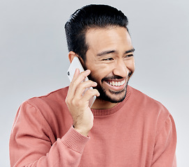 Image showing Asian man, phone call and laughing for funny conversation, discussion or joke against a white studio background. Happy male laugh and talking on mobile smartphone for fun chat, communication or meme