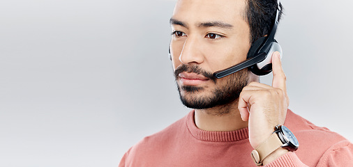 Image showing Headset, support and a man for a call center with mockup isolated on white background. Contact us, thinking and Asian customer service employee consulting for telemarketing on a backdrop with space