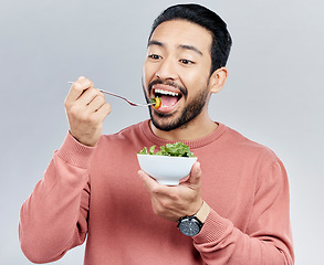 Image showing Man, salad and eating healthy food in studio for health or wellness motivation for vegetables. Asian male vegetable bowl for nutrition, diet and benefits for digestion or lose weight white background