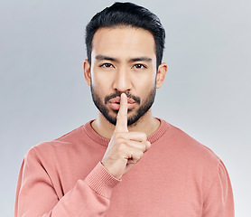 Image showing Secret, finger on lips and portrait of man in studio with privacy, silence and confidential hand gesture. Communication mockup, emoji and face of male on grey background for shush, whisper or gossip