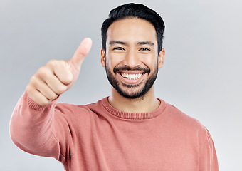 Image showing Portrait, great and Asian man with thumbs up, vote and happiness against a studio background. Face, Japanese male and guy with gesture for well done, promotion and agreement with smile and approval