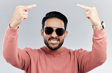 Image showing Portrait, rude and man with anger, middle finger and frustrated against grey studio background. Face, male and guy with offensive hand gesture, aggressive and conflict with expression and disrespect