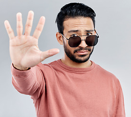 Image showing Stop, portrait and a cool man with sunglasses isolated on a white background in a studio. No, rejection and an Asian guy with a hand sign for warning, security and bouncer with decline on a backdrop