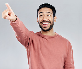 Image showing Mockup, smile and Asian man pointing, promotion and product placement against grey studio background. Japan, male and happy guy with gesture for direction, space and brand development with happiness