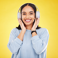 Image showing Happy, music and headphones with portrait of woman in studio for streaming, online radio and audio. Smile, media and podcast with female on yellow background for technology, listening and connection