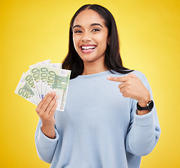 Image showing Woman, happy and cash in studio portrait for bonus, winning or profit by yellow background. Young student girl, winner and money fan with pointing at bills for celebration of success on stock market