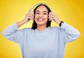 Image showing Laugh, music and headphones with portrait of woman in studio for streaming, online radio and audio. Smile, media and podcast with female on yellow background for technology, listening and connection