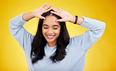 Image showing Happy, dance and face of woman on yellow background for positive mindset, happiness and freedom. Smile, mockup space and isolated girl with hands on head for dancing, relaxing and calm in studio