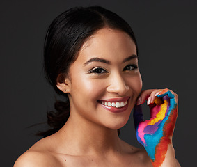 Image showing Woman, portrait and beauty smile with rainbow paint hand or art on and face in studio. Creative skin and makeup on female aesthetic model on gray background for lgbtq color inspiration on hands