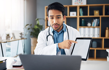 Image showing Mockup, pointing and a doctor on a video call with a tablet for results, healthcare support and advice. Talking, consulting and an Asian gp with a blank screen tech for a telehealth webinar on a pc