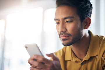 Image showing Serious asian man, phone and social media for communication or networking at home. Focused male freelancer face on mobile smartphone app for chatting, texting or browsing on internet or research