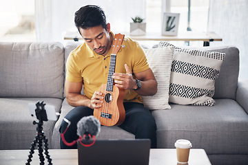 Image showing Guitar, podcast and phone with a man online teaching, show and coach on live streaming lesson. Asian male person happy on home sofa with a ukulele as content creator teaching music on education blog