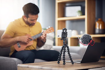 Image showing Streaming, ukulele and phone with a man online to coach during live lesson. Asian male person on home sofa with a guitar as content creator or influencer teaching music on education podcast blog