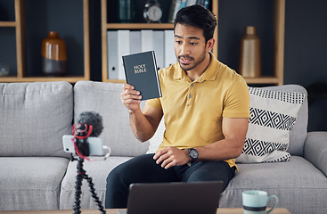 Image showing Streaming, bible and man talking on phone and microphone online for live podcast. Asian male on home sofa with Christian religion book as blog content creator or influencer teaching or studying