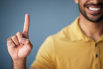 Image showing Asian man, hand and smile, pointing up in studio with mockup for choice or vote on blue background. Location, finger showing deal announcement or information with happy mock up space for notification