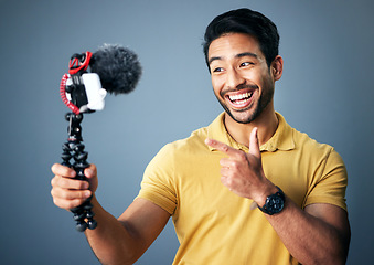 Image showing Phone, content creation and Indian man in studio with smile, webinar recording and live streaming on grey background. Internet, webcam and happy online influencer with smile on social media channel.