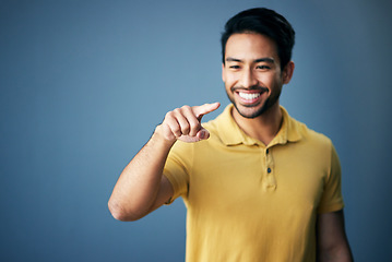 Image showing Mockup, smile and Asian man pointing, space and product placement against blue studio background. Japan, male and happy guy with brand development, happiness and suggestion with promotion and choice