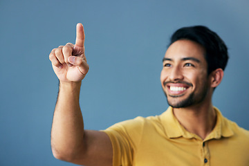 Image showing Finger, pointing and happy man in studio with hand gesture, sign or showing mockup on blue background. Smile, point and asian male with idea on space for advertising, product placement and isolated