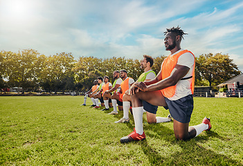 Image showing Sports, training and team outdoor for rugby on a grass field with men doing knee exercise. Athlete group together for fitness and workout for professional sport with diversity, support and teamwork