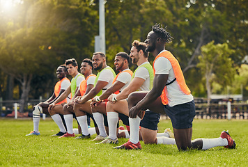 Image showing Rugby sport, diversity and men training outdoor on a grass field with a team happy for knee exercise. Athlete group together for fitness, motivation and workout for sports club and strong teamwork