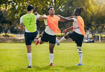 Image showing Sports men, training and outdoor rugby on a grass field with a team stretching legs as warm up. Athlete group together for fitness, exercise and workout for diversity sport with coach and teamwork