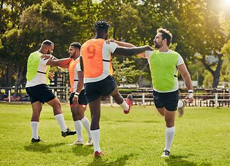 Image showing Sports, rugby men and training outdoor on grass field with team stretching legs as warm up. Male athlete group together for fitness, exercise and workout for sport with support and club teamwork