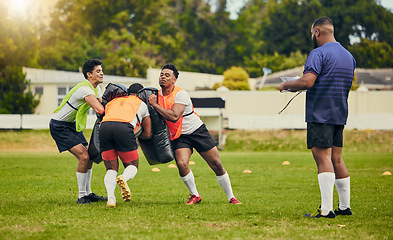 Image showing Rugby, teamwork and men training on field with equipment ready for match, practice and sport games. Fitness, competition and male athletes tackle bag for warm up, exercise and workout with coach