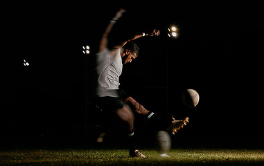 Image showing Rugby, night and man kicking ball to score goal at dark stadium at game, match or practice workout. Sports, fitness and motion, player with blurred action on grass with energy and skill in team sport