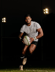 Image showing Rugby, night and man running with ball to score goal at dark stadium at game, match or practice workout. Sports, fitness and motion, player with action on grass with energy and skill in team sport.