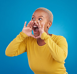 Image showing Screaming, announcement and loud with a black woman on a blue background in studio for news or communication. Hand, shouting or message and a young female yelling to alert danger with her voice