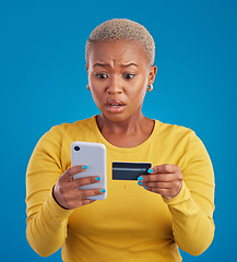 Image showing Credit card, phone and worried woman online shopping mistake, transaction fail or debt isolated on blue background. Stress, anxiety and confused person fintech payment, hacking or phishing in studio