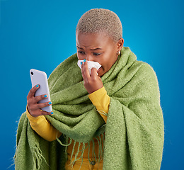 Image showing Sick black woman, phone and blowing nose on background, studio and allergies from winter virus. Female model, influenza and smartphone for telehealth app, covid healthcare and search symptoms online