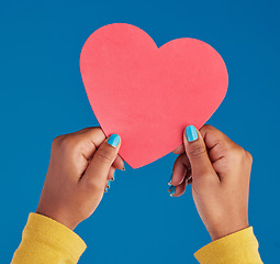 Image showing Paper, heart and hands of black woman in studio for love, date and kindness. Invitation, romance and feelings with female and shape isolated on blue background for emotion, support and affectionate