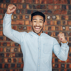 Image showing Portrait, winner and motivation with a man in celebration against a brick wall background enjoying victory. Energy, wow and success with a handsome young man celebrating an achievement or bonus