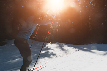 Image showing Nordic skiing or Cross-country skiing classic technique practiced by man in a beautiful panoramic trail at morning.