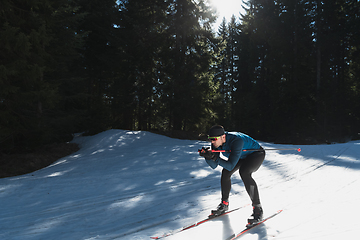 Image showing Nordic skiing or Cross-country skiing classic technique practiced by man in a beautiful panoramic trail at morning.